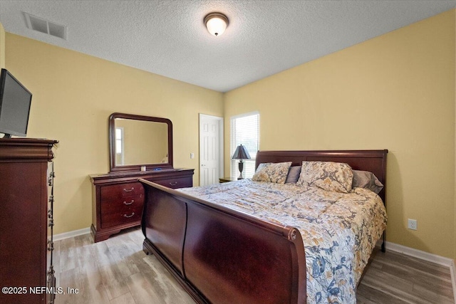 9955 Kings Crossing Dr E, Jacksonville, FL 32219 - bedroom featuring wood finished floors, a textured ceiling, and baseboards