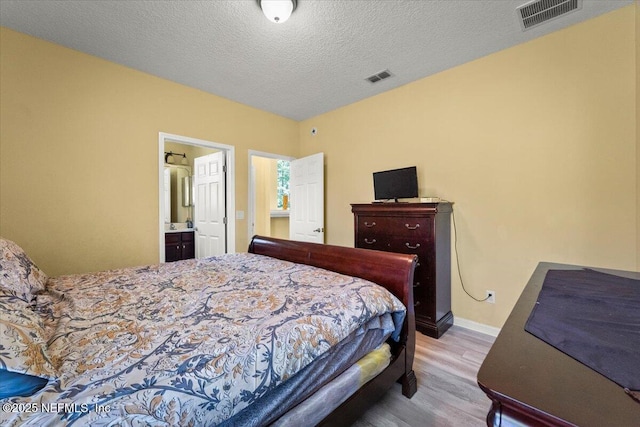 9955 Kings Crossing Dr E, Jacksonville, FL 32219 - bedroom with wood finished floors, baseboards, ensuite bathroom, and a textured ceiling