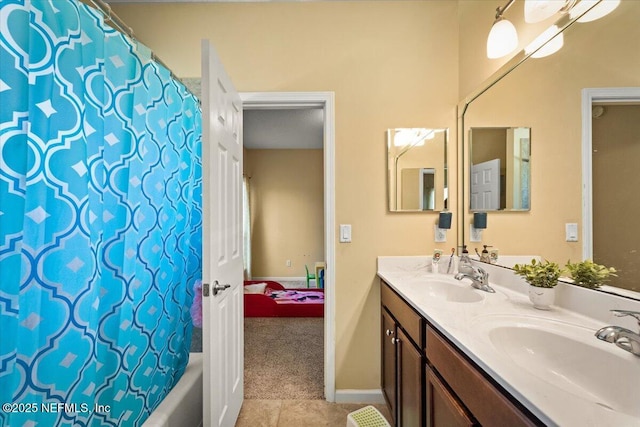 9955 Kings Crossing Dr E, Jacksonville, FL 32219 - ensuite bathroom featuring double vanity, tile patterned flooring, shower / bath combo with shower curtain, and baseboards