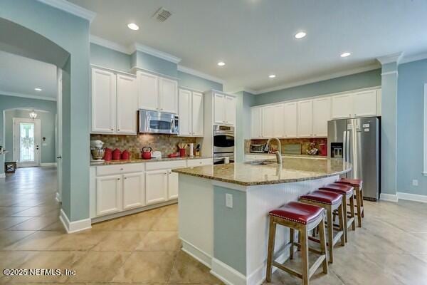 167 Royal Lake Dr, Ponte Vedra, FL 32081 - kitchen featuring stainless steel appliances, crown molding, recessed lighting, tasteful backsplash, and white cabinetry