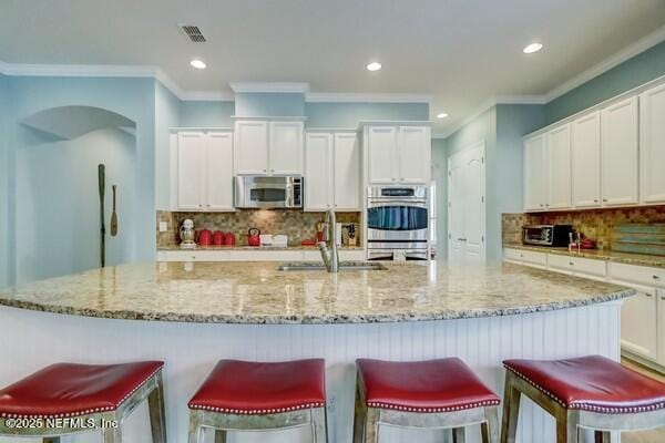 167 Royal Lake Dr, Ponte Vedra, FL 32081 - kitchen with stainless steel appliances, a sink, decorative backsplash, white cabinetry, and recessed lighting