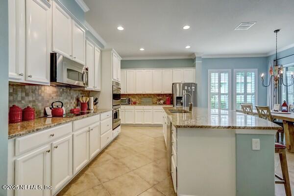 167 Royal Lake Dr, Ponte Vedra, FL 32081 - kitchen featuring stainless steel appliances, crown molding, backsplash, white cabinets, and a sink