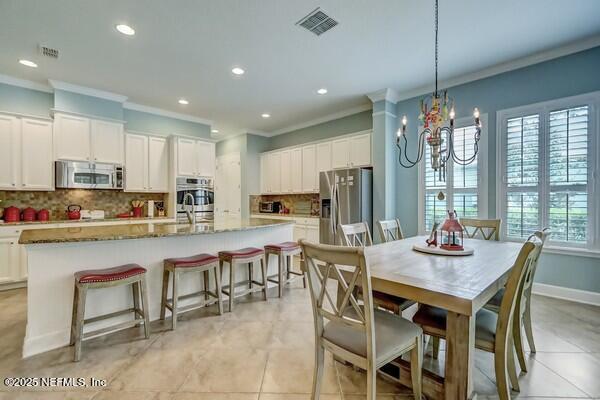 167 Royal Lake Dr, Ponte Vedra, FL 32081 - dining room with crown molding, a chandelier, recessed lighting, light tile patterned floors, and baseboards