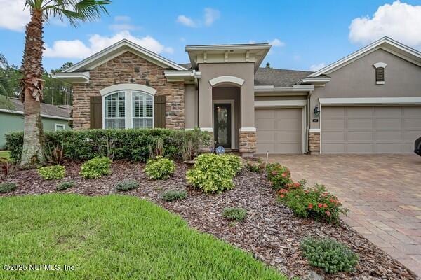 167 Royal Lake Dr, Ponte Vedra, FL 32081 - view of front of house with stone siding, stucco siding, a garage, and driveway