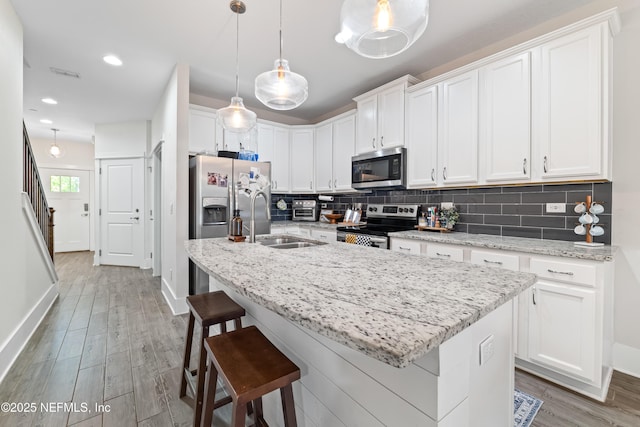 622 2nd Ave N, Jacksonville Beach, FL 32250 - kitchen featuring stainless steel appliances, a sink, backsplash, white cabinetry, and recessed lighting