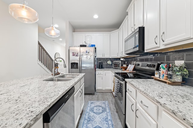 622 2nd Ave N, Jacksonville Beach, FL 32250 - kitchen featuring appliances with stainless steel finishes, a sink, light wood-type flooring, white cabinetry, and recessed lighting