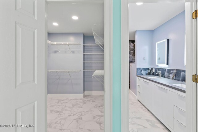 50 Rivers Edge Ln, Palm Coast, FL 32137 - full bath with marble look tile flooring, double vanity, a walk in closet, and recessed lighting