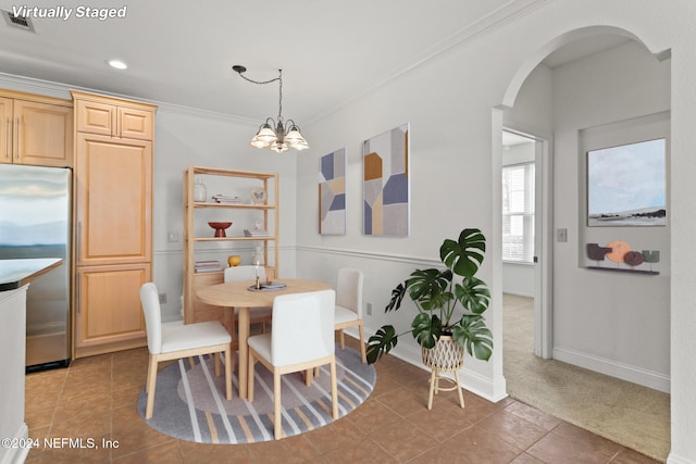 13810 Sutton Park Dr N Unit 511, Jacksonville, FL 32224 - dining space featuring a chandelier, ornamental molding, tile patterned flooring, arched walkways, and baseboards