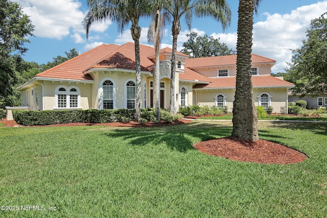 2579 Woodgrove Rd, Fleming Island, FL 32003 - mediterranean / spanish house featuring stucco siding, a tiled roof, and a front lawn