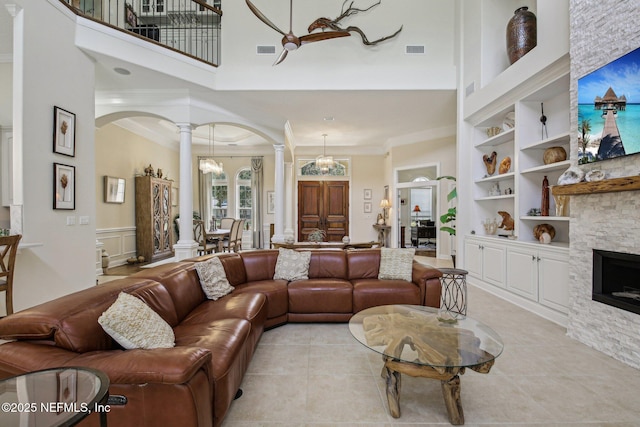 2579 Woodgrove Rd, Fleming Island, FL 32003 - living area with ornate columns, arched walkways, a towering ceiling, built in shelves, and a chandelier