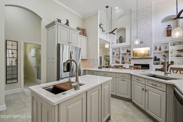 2579 Woodgrove Rd, Fleming Island, FL 32003 - kitchen with stainless steel appliances, a sink, a towering ceiling, light tile patterned flooring, and crown molding