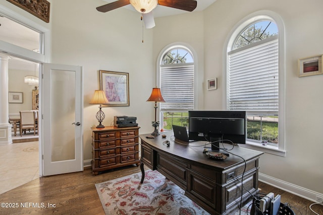 2579 Woodgrove Rd, Fleming Island, FL 32003 - office with ceiling fan, ornate columns, dark wood-type flooring, baseboards, and a high ceiling