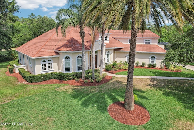 2579 Woodgrove Rd, Fleming Island, FL 32003 - mediterranean / spanish-style house with a tile roof, stucco siding, and a front lawn