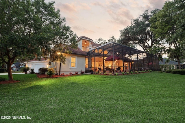 2579 Woodgrove Rd, Fleming Island, FL 32003 - rear view of house featuring a lawn, a lanai, an attached garage, and a tiled roof