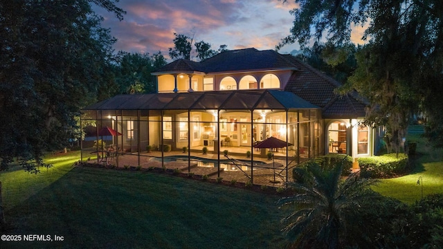 2579 Woodgrove Rd, Fleming Island, FL 32003 - back of house at dusk featuring a patio area, a yard, and stucco siding