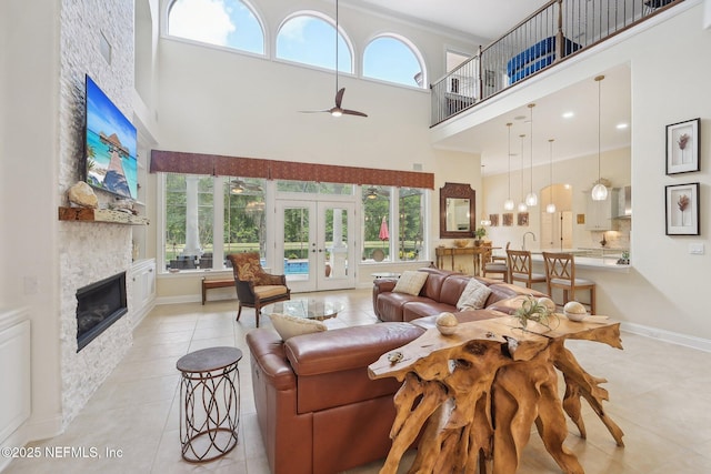 2579 Woodgrove Rd, Fleming Island, FL 32003 - living room featuring a high ceiling, light tile patterned floors, healthy amount of natural light, a ceiling fan, and a fireplace