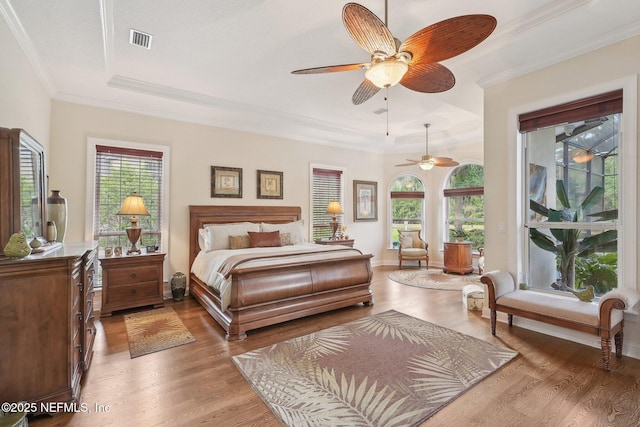 2579 Woodgrove Rd, Fleming Island, FL 32003 - bedroom with a tray ceiling, crown molding, wood finished floors, ceiling fan, and access to exterior