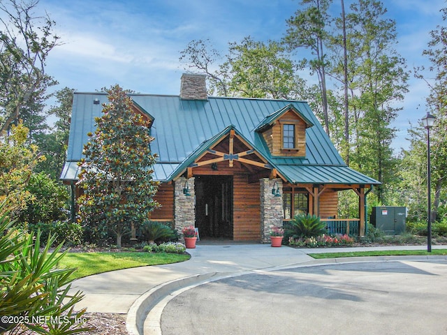 2579 Woodgrove Rd, Fleming Island, FL 32003 - view of front of property with a standing seam roof, a chimney, covered porch, metal roof, and stone siding