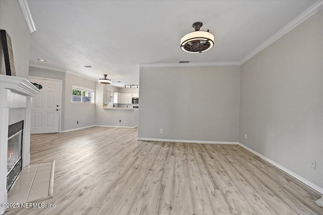 1800 The Greens Way Unit 406, Jacksonville Beach, FL 32250 - unfurnished living room featuring crown molding, light wood-style floors, baseboards, and a tiled fireplace