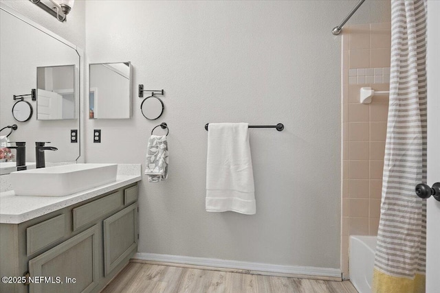 1800 The Greens Way Unit 406, Jacksonville Beach, FL 32250 - bathroom featuring vanity, shower / bathtub combination with curtain, baseboards, and wood finished floors