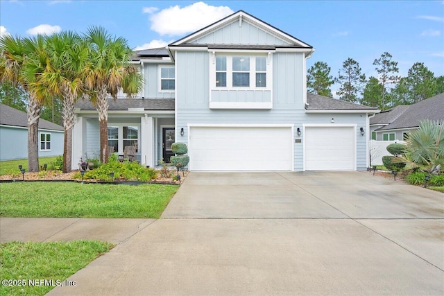 2629 Cold Stream Ln, Green Cove Springs, FL 32043 - traditional-style house with board and batten siding, an attached garage, driveway, roof mounted solar panels, and a front yard