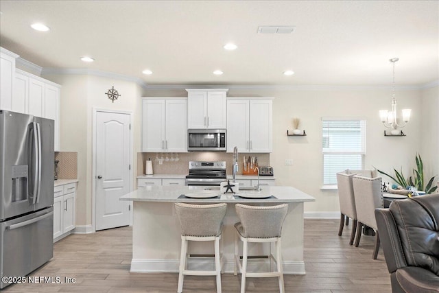 2629 Cold Stream Ln, Green Cove Springs, FL 32043 - kitchen featuring appliances with stainless steel finishes, ornamental molding, decorative backsplash, light wood-style floors, and a chandelier