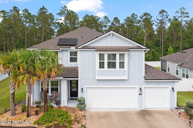 2629 Cold Stream Ln, Green Cove Springs, FL 32043 - traditional home with roof with shingles, board and batten siding, solar panels, concrete driveway, and an attached garage