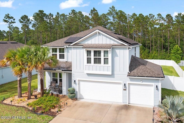 2629 Cold Stream Ln, Green Cove Springs, FL 32043 - view of front of home with board and batten siding, a garage, roof mounted solar panels, roof with shingles, and driveway