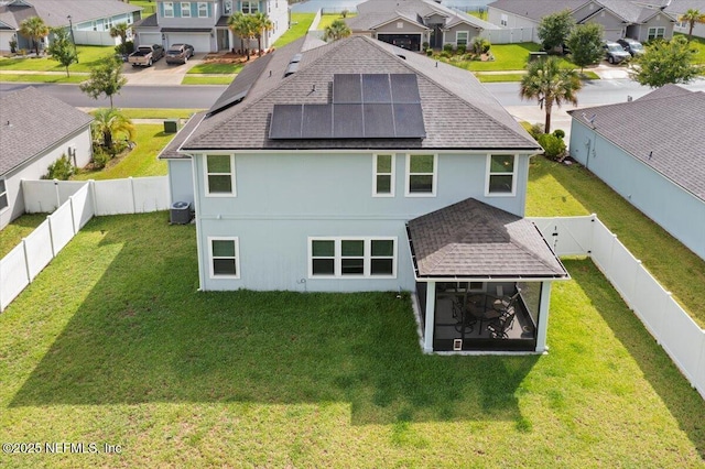 2629 Cold Stream Ln, Green Cove Springs, FL 32043 - rear view of house featuring a shingled roof, a residential view, a fenced backyard, roof mounted solar panels, and a sunroom