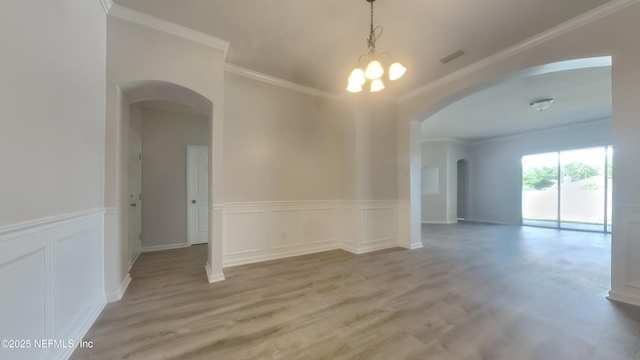 4053 Trail Ridge Rd, Middleburg, FL 32068 - spare room featuring arched walkways, light wood-type flooring, ornamental molding, a decorative wall, and wainscoting