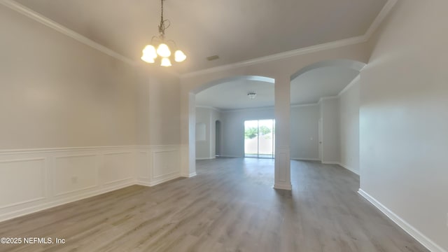 4053 Trail Ridge Rd, Middleburg, FL 32068 - empty room with arched walkways, crown molding, light wood finished floors, a chandelier, and baseboards