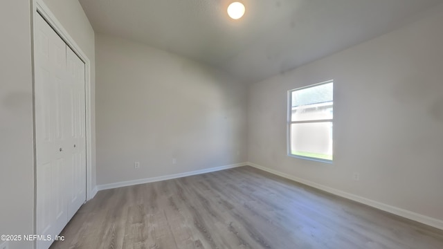 4053 Trail Ridge Rd, Middleburg, FL 32068 - unfurnished bedroom featuring lofted ceiling, light wood-type flooring, a closet, and baseboards