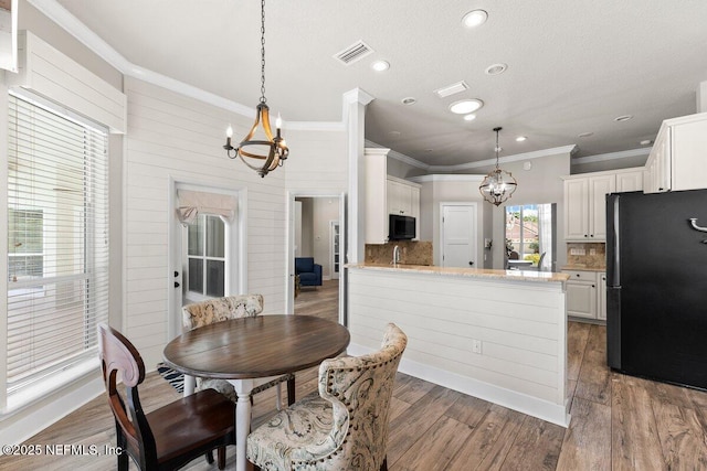 1759 Rising Oaks Dr, Jacksonville, FL 32223 - dining space featuring a chandelier, ornamental molding, wood finished floors, and recessed lighting