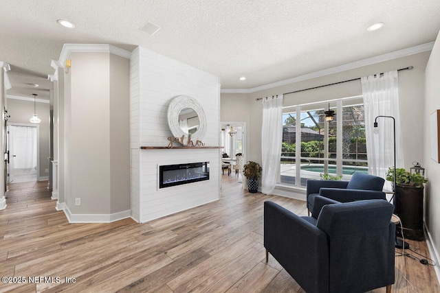 1759 Rising Oaks Dr, Jacksonville, FL 32223 - living room featuring crown molding, wood finished floors, a large fireplace, baseboards, and a textured ceiling