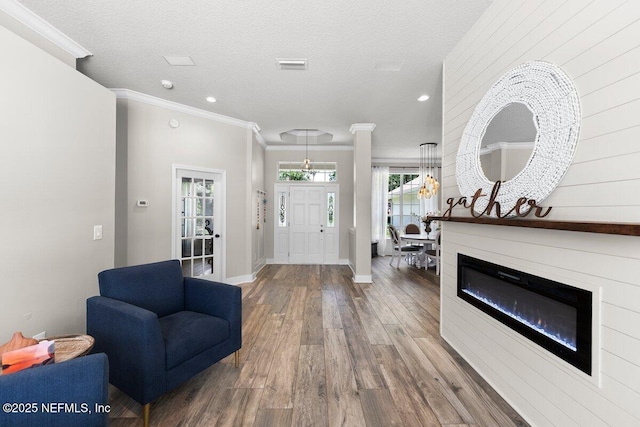1759 Rising Oaks Dr, Jacksonville, FL 32223 - foyer featuring wood finished floors, baseboards, crown molding, recessed lighting, and a glass covered fireplace