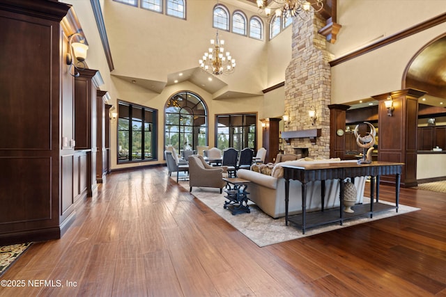 109 Sweet Pine Trl, Ponte Vedra, FL 32081 - living area featuring a high ceiling, decorative columns, a chandelier, dark wood-style floors, and a stone fireplace