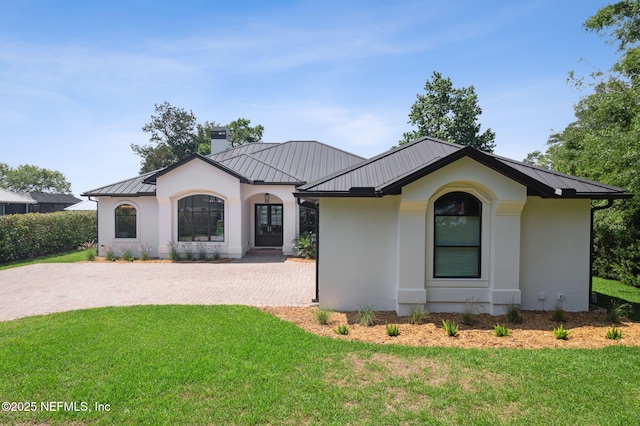 95544 Wilder Blvd, Fernandina Beach, FL 32034 - view of front facade featuring a standing seam roof, metal roof, a front lawn, and stucco siding