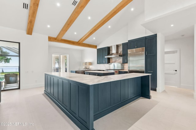 95544 Wilder Blvd, Fernandina Beach, FL 32034 - kitchen featuring premium appliances, a spacious island, wall chimney exhaust hood, beam ceiling, and plenty of natural light