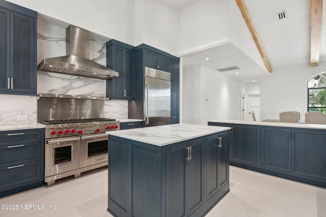 95544 Wilder Blvd, Fernandina Beach, FL 32034 - kitchen featuring high quality appliances, wall chimney exhaust hood, decorative backsplash, a center island, and light stone countertops