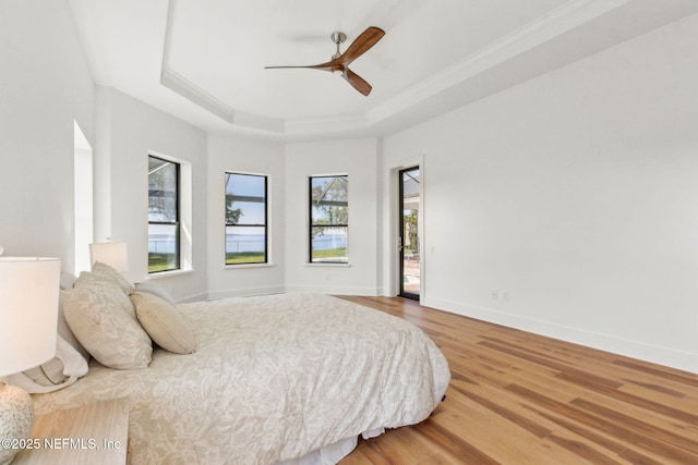 95544 Wilder Blvd, Fernandina Beach, FL 32034 - bedroom featuring a tray ceiling, wood finished floors, ornamental molding, baseboards, and ceiling fan