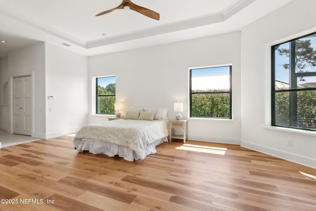 95544 Wilder Blvd, Fernandina Beach, FL 32034 - bedroom with multiple windows, light wood finished floors, a raised ceiling, and crown molding
