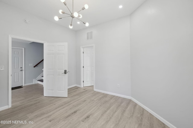 2010 N Main St, Jacksonville, FL 32206 - empty room featuring light wood-style floors, a chandelier, baseboards, stairs, and a smoke detector