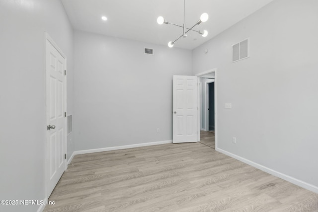 2010 N Main St, Jacksonville, FL 32206 - spare room with a chandelier, light wood-style flooring, and baseboards