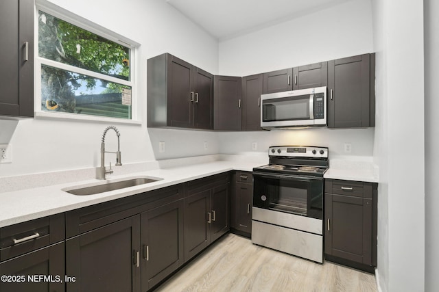 2010 N Main St, Jacksonville, FL 32206 - kitchen with stainless steel appliances, a sink, light countertops, and light wood finished floors
