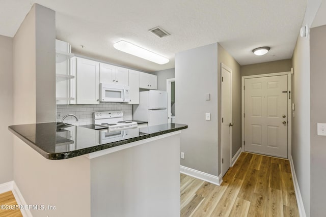 7701 Timberlin Park Blvd Unit 331, Jacksonville, FL 32256 - kitchen with white appliances, open shelves, a peninsula, and light wood-type flooring