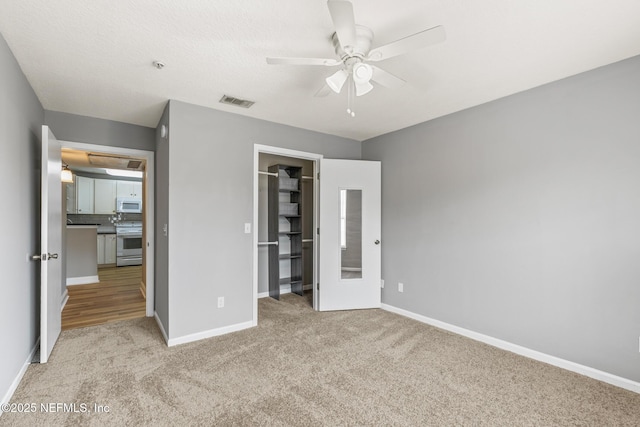 7701 Timberlin Park Blvd Unit 331, Jacksonville, FL 32256 - unfurnished bedroom with carpet flooring, baseboards, a walk in closet, a ceiling fan, and a closet