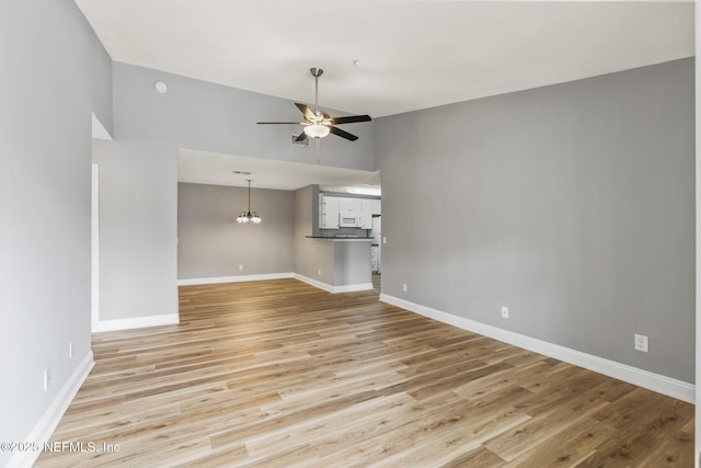 7701 Timberlin Park Blvd Unit 331, Jacksonville, FL 32256 - empty room featuring ceiling fan, light wood finished floors, baseboards, and a chandelier