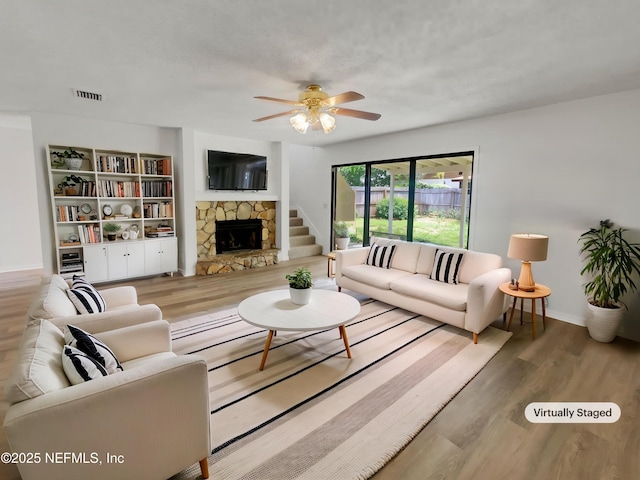 1127 Romaine Cir W, Jacksonville, FL 32225 - living area featuring wood finished floors, ceiling fan, a fireplace, and baseboards