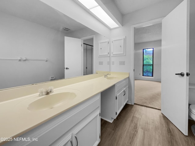 1127 Romaine Cir W, Jacksonville, FL 32225 - bathroom featuring toilet, double vanity, wood finished floors, and a shower