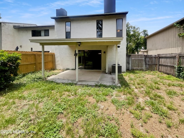 1127 Romaine Cir W, Jacksonville, FL 32225 - back of house with a patio area, a fenced backyard, stucco siding, and central AC